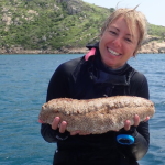 Ali Hammond Marine Scientist holds a sea cucumber